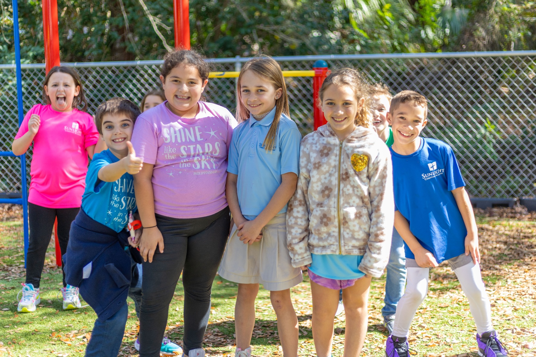 Lower elementary students smiling together on the playground